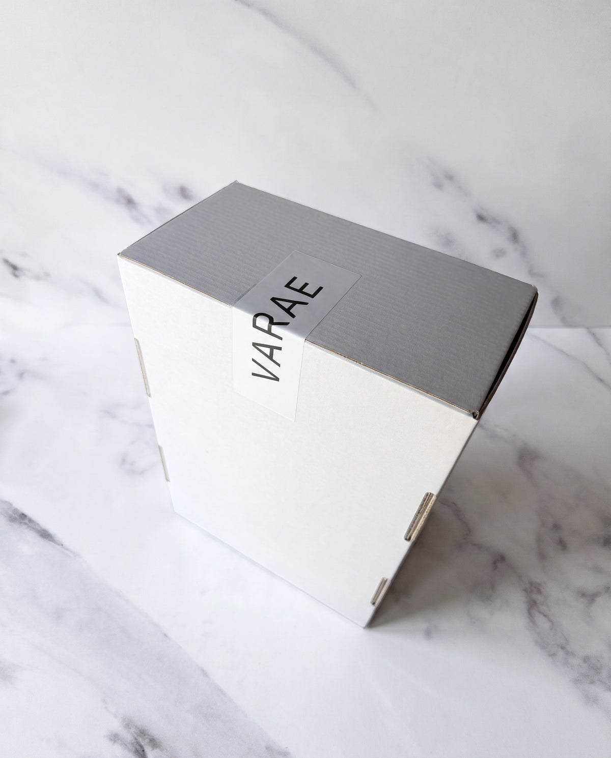 VARAE gift box, closed with a VARAE seal sticker, on white marble