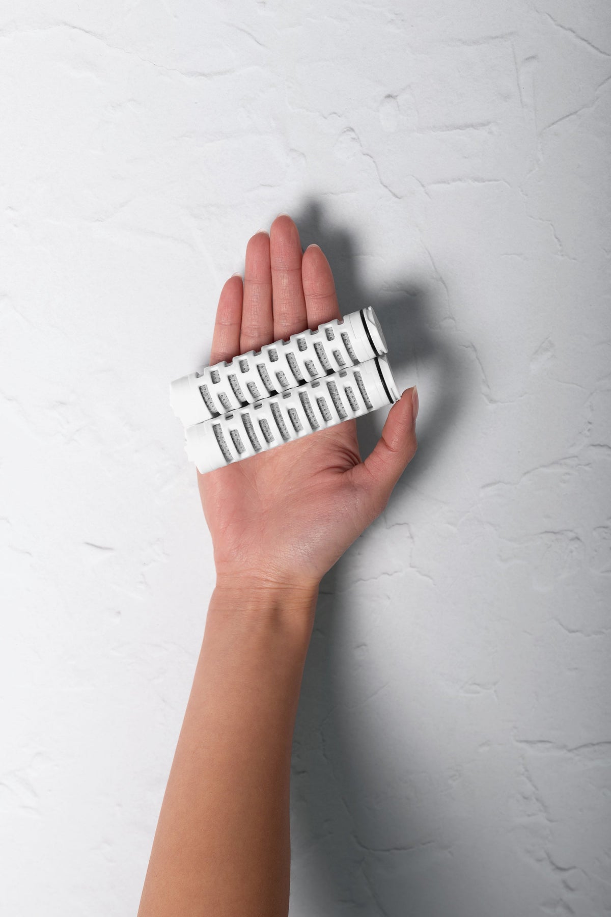 Two VARAE replacement filter cartridges held in an open hand to show their size