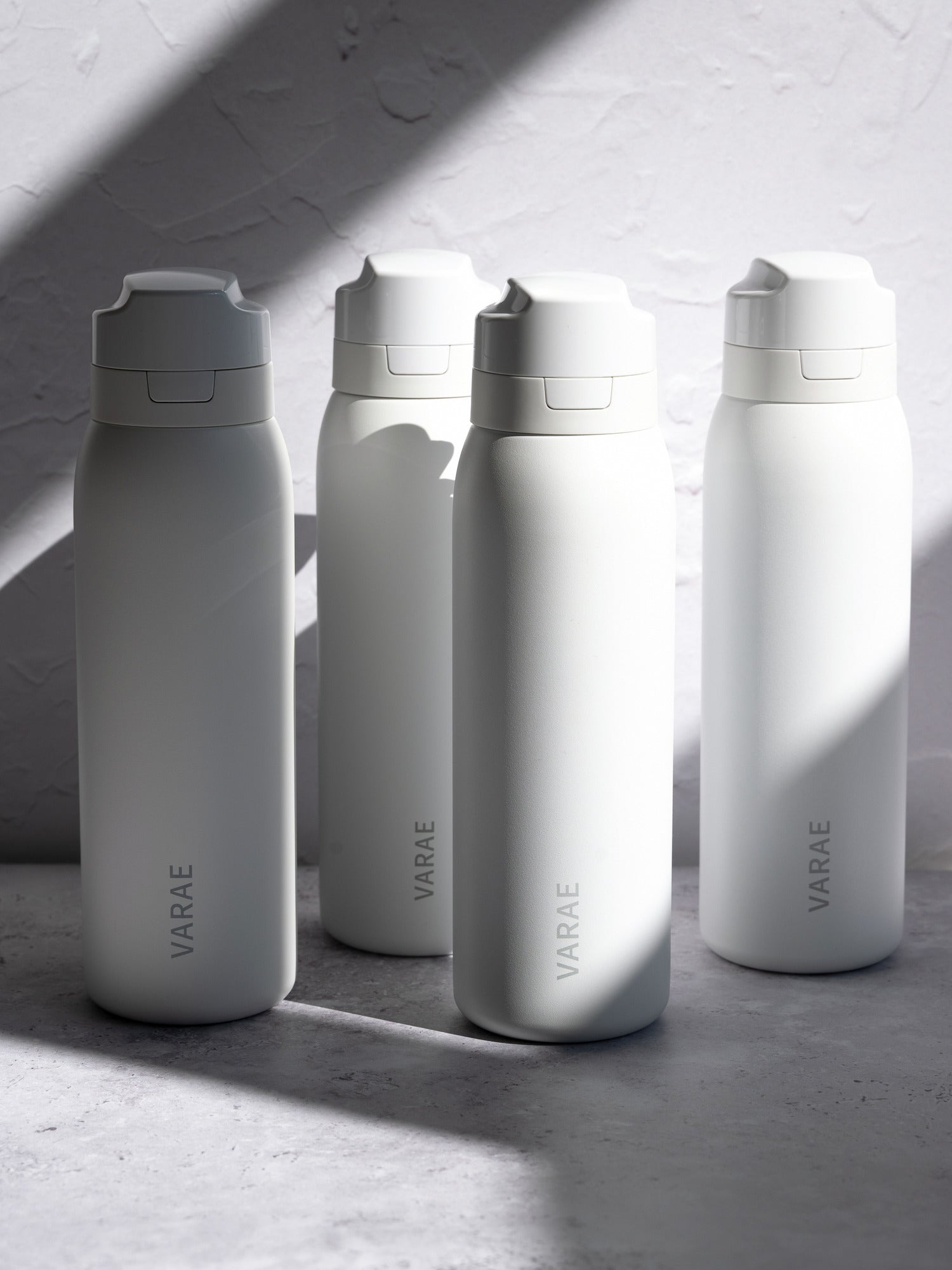Four VARAE Pure bottles together in window light.